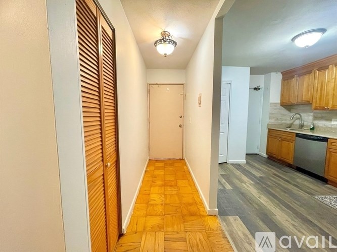A hallway with wooden floors and a white door.