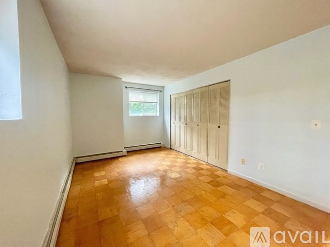 A room with wooden flooring and white walls.