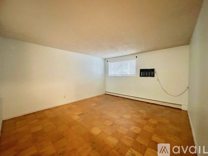 A room with wooden flooring and a window.
