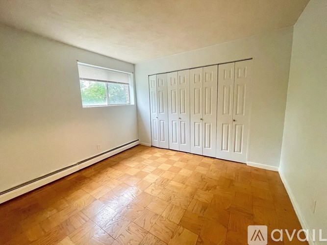 A room with a window and a set of white doors.