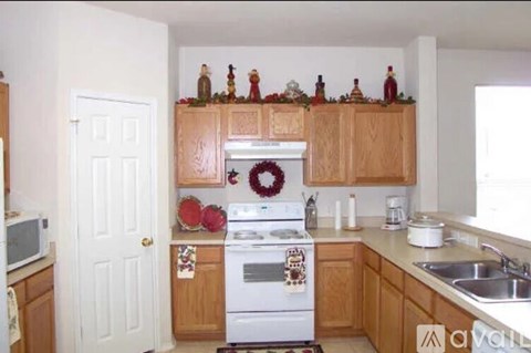 A kitchen with a white oven and wooden cabinets.