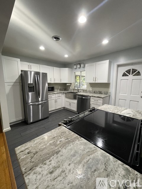 A kitchen with a black countertop and stainless steel appliances.