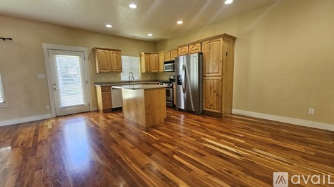 A kitchen with wooden cabinets and a stainless steel refrigerator.