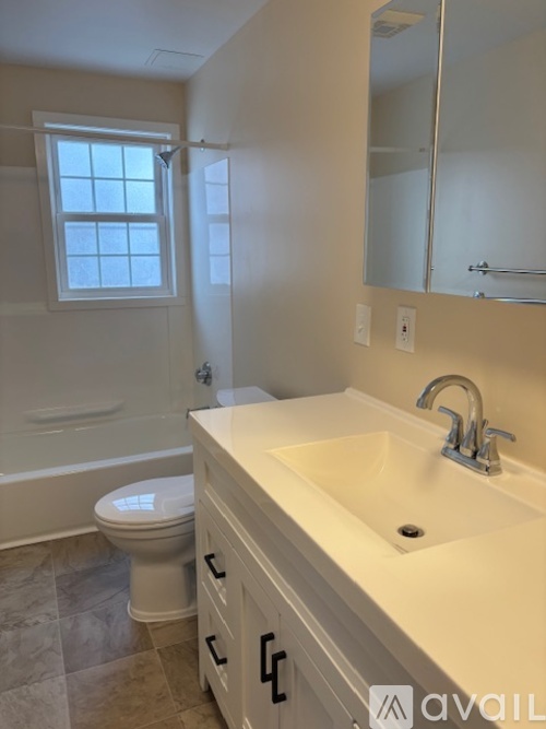 A bathroom with a toilet, sink, and tub.