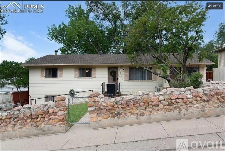 A house with a stone wall in front.