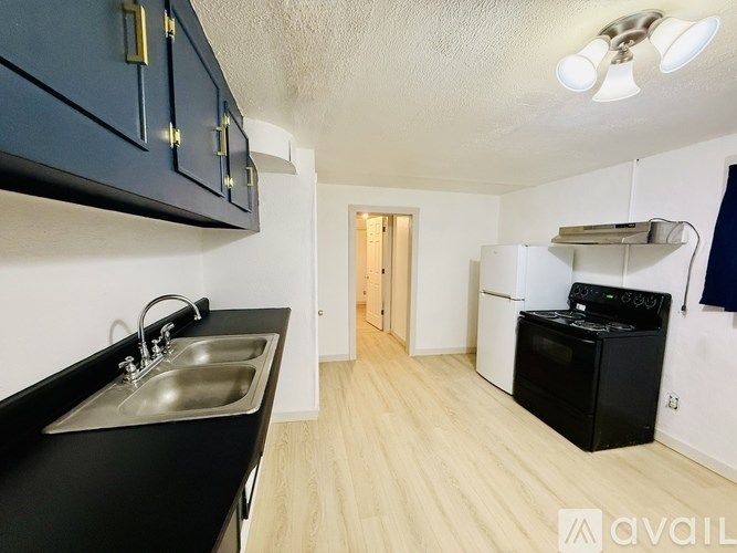 A kitchen with black cabinets and a stainless steel sink.