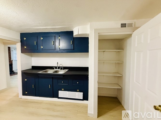 A kitchen with dark blue cabinets and a white sink.