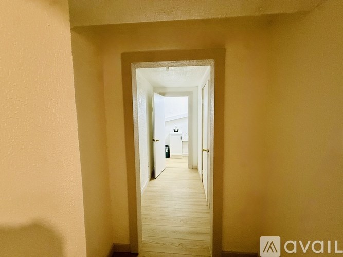 A hallway with a doorway leading to another room.