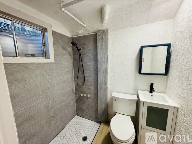 A bathroom with a toilet, sink, and shower.