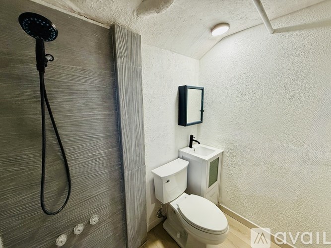 A small bathroom with a toilet, sink, and shower.