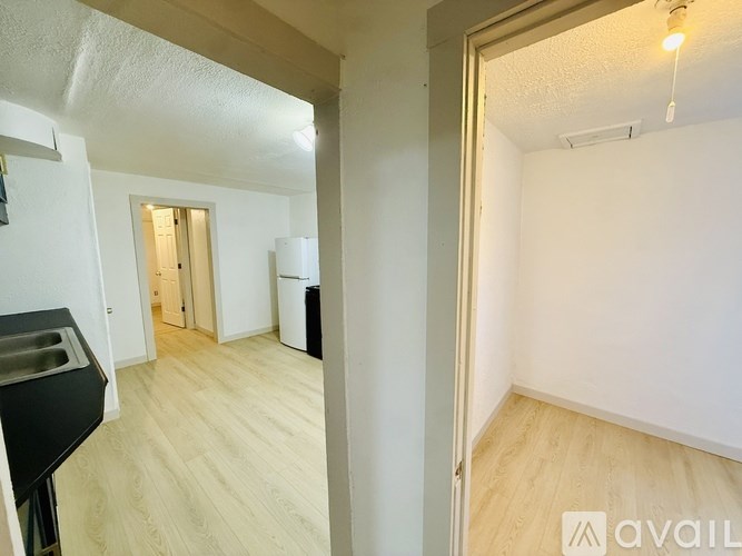 A kitchen area with a sink and a white wall.