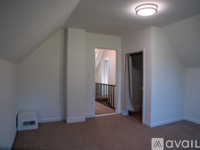 A carpeted room with a small white box on the floor.