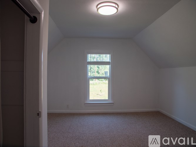 A small room with a window and carpeted floor.
