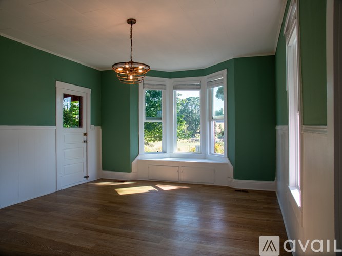 A room with green walls and a wooden floor.