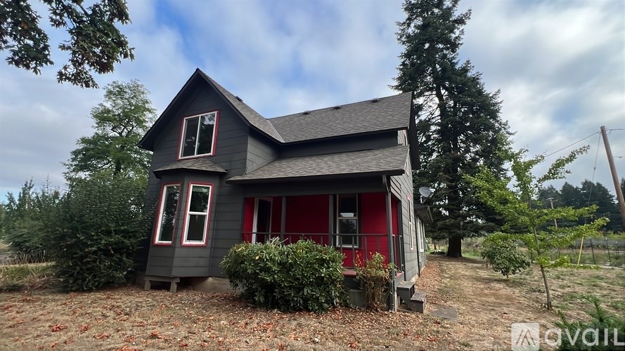 A small house with a red door and a grey roof.