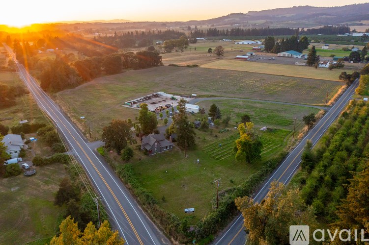 A sunset view of a rural area with a road running through it.