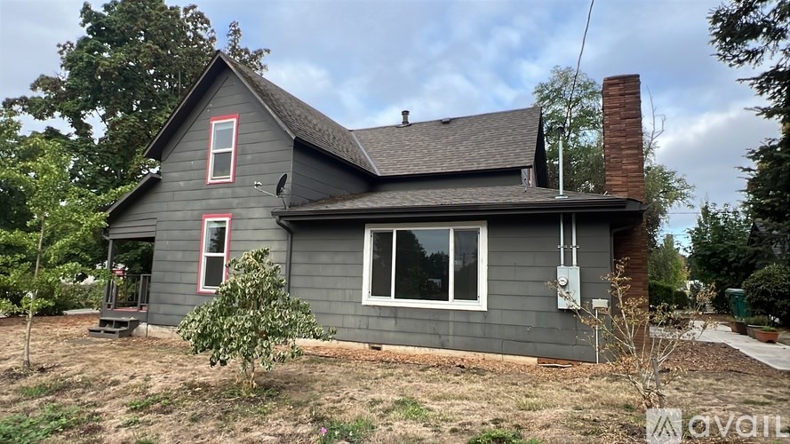 A house with a grey exterior and a red window trim.