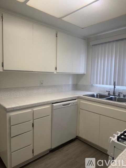 A kitchen with white cabinets and a white countertop.