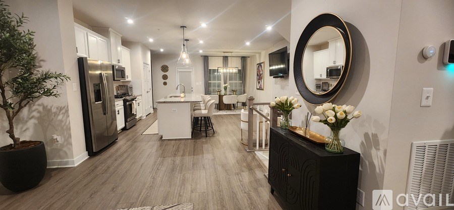 A modern kitchen with a black cabinet and a round mirror on the wall.