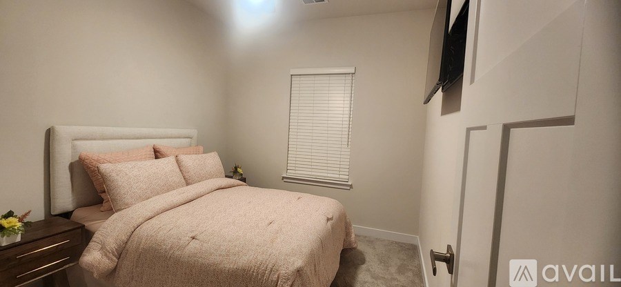 A bedroom with a large bed and a flat screen TV mounted on the wall.