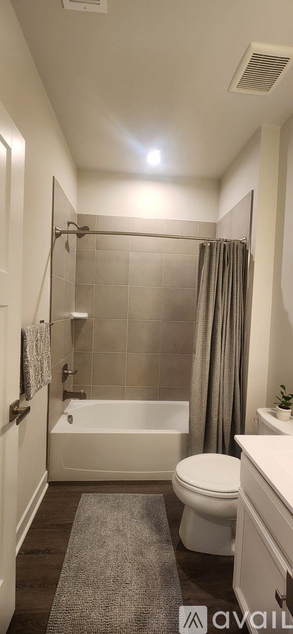 A bathroom with a toilet, a bathtub, and a shower curtain.