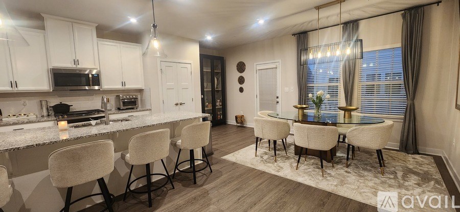 A modern kitchen with white cabinets and a dining area with a table and chairs.