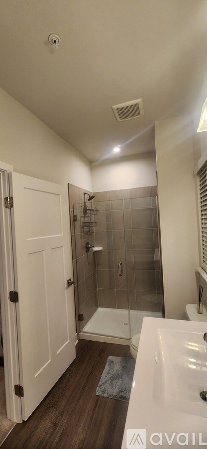 A bathroom with a white door and a white bathtub.