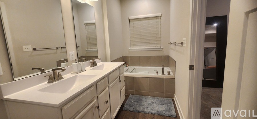 A bathroom with a double sink and a bathtub.