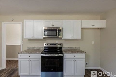 A kitchen with white cabinets and a granite countertop.