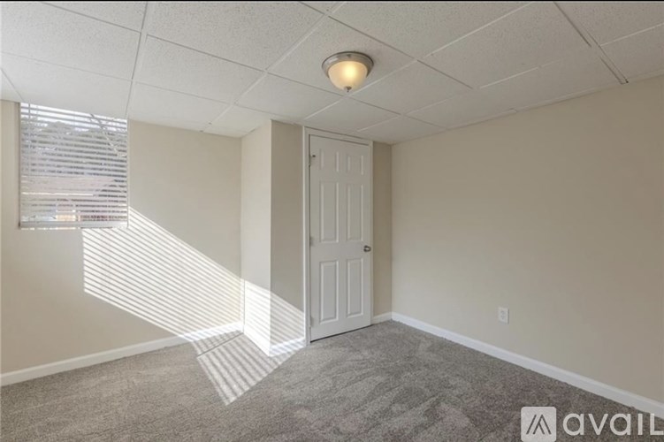 A room with a door and a window with blinds.