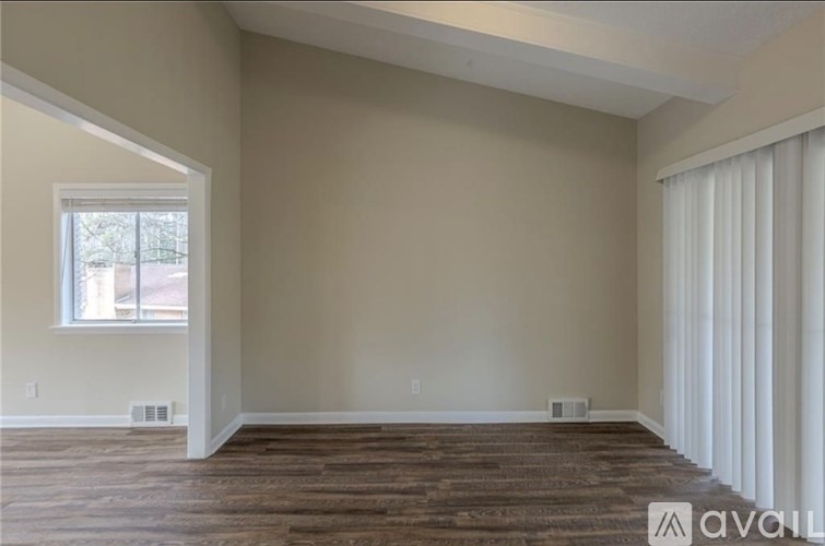 A house with a white fence is surrounded by trees.
