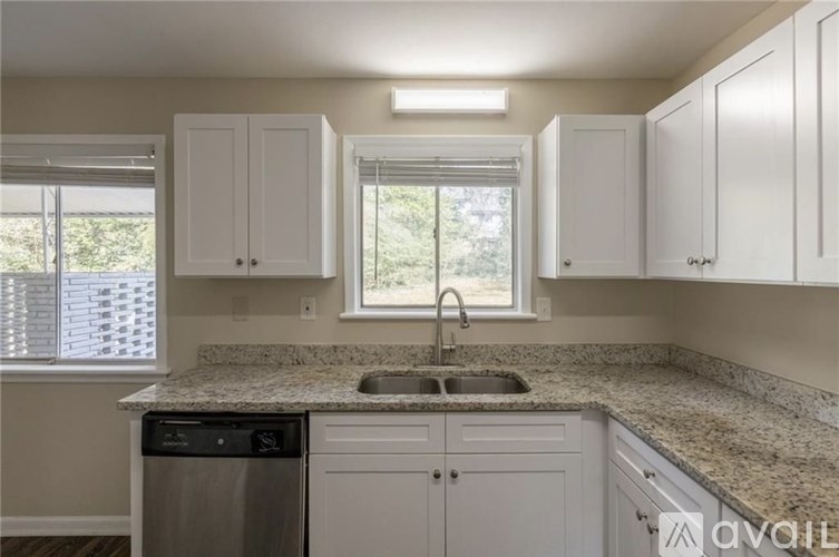 A room with a white door, a white wall, and a white ceiling.