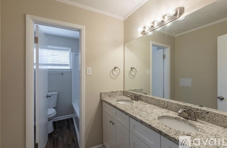 A bathroom with a granite countertop and a large mirror.