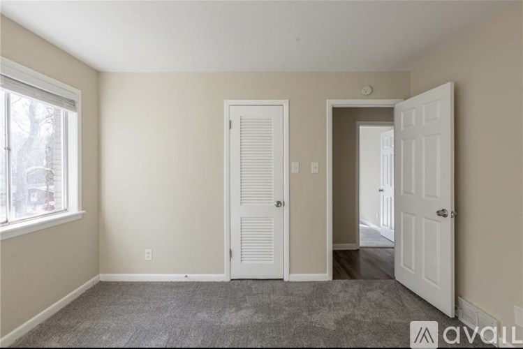A room with two white doors and a window.