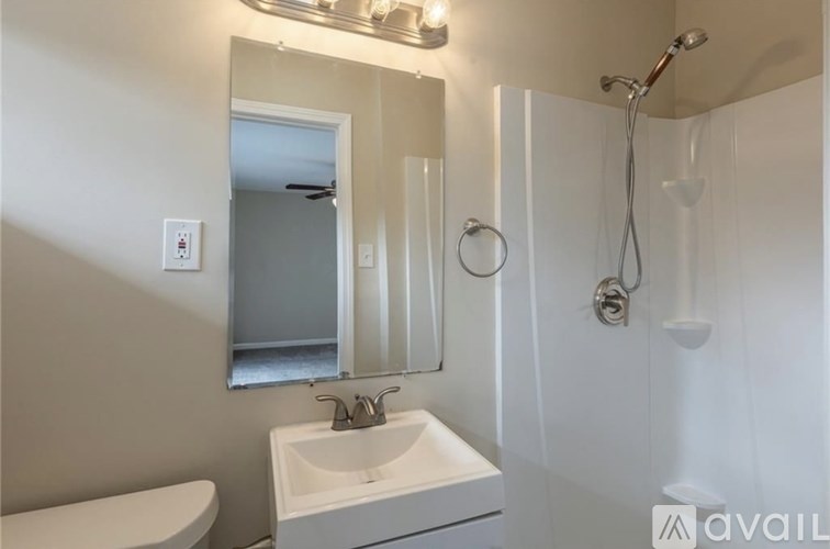 A bathroom with a white sink and a mirror above it.