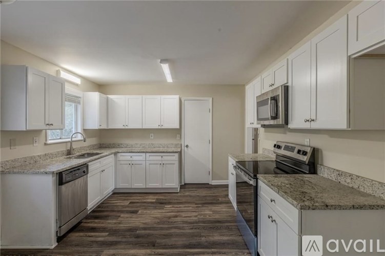 A kitchen with white cabinets and a granite countertop.