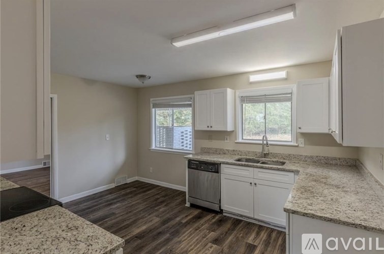 A kitchen with a granite countertop and wooden flooring.