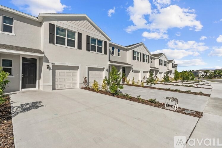 A row of houses with the first one having a garage door that is open.