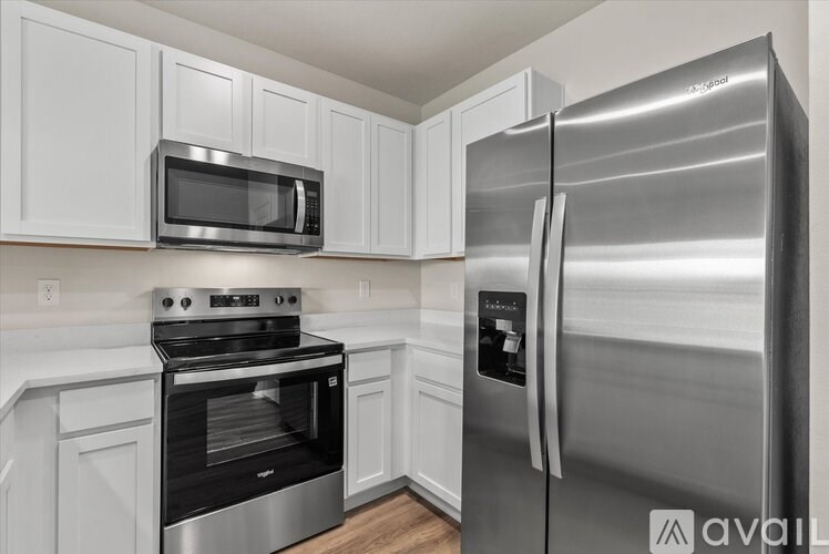 A kitchen with a stainless steel refrigerator, oven, and microwave.