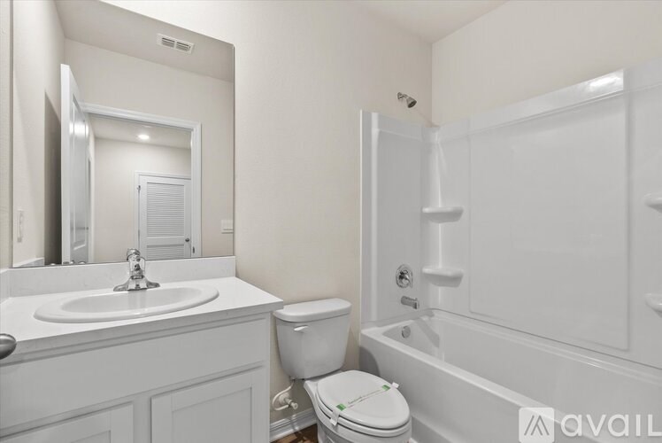A white bathroom with a toilet, sink, and bathtub.