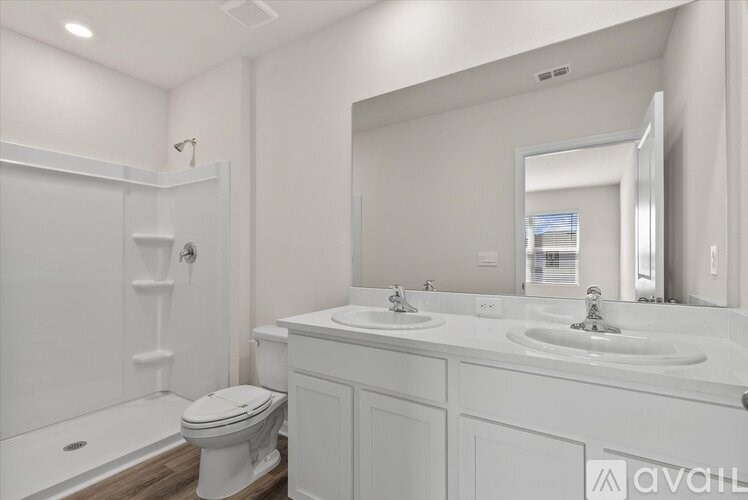 A white bathroom with a toilet, sink, and mirror.