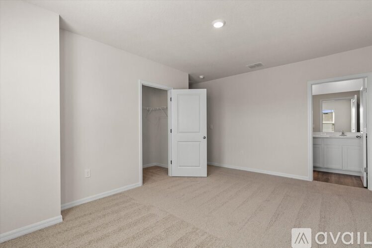 A room with a white door and a carpeted floor.