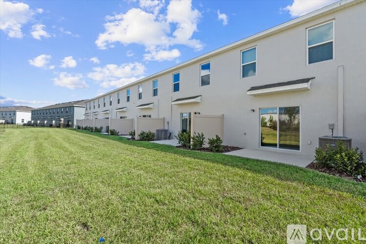 A row of modern houses with green lawns in front.