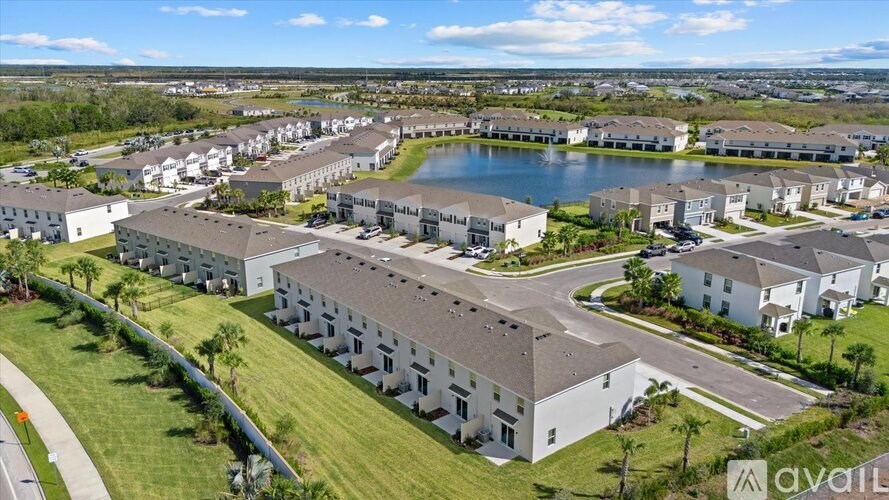 A bird's eye view of a residential area with a lake in the middle.