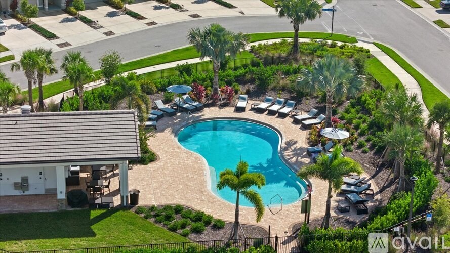 A pool surrounded by palm trees and a house.