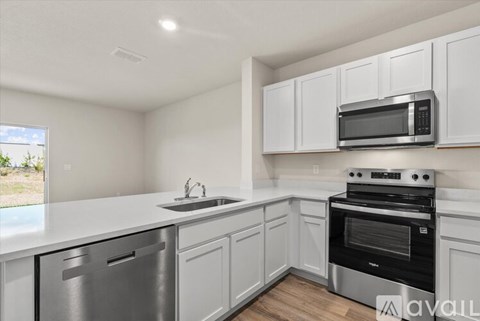 A kitchen with white cabinets and stainless steel appliances.