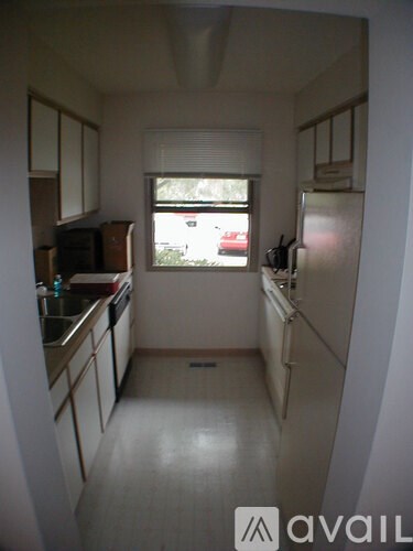 A kitchen with white cabinets and a white fridge.