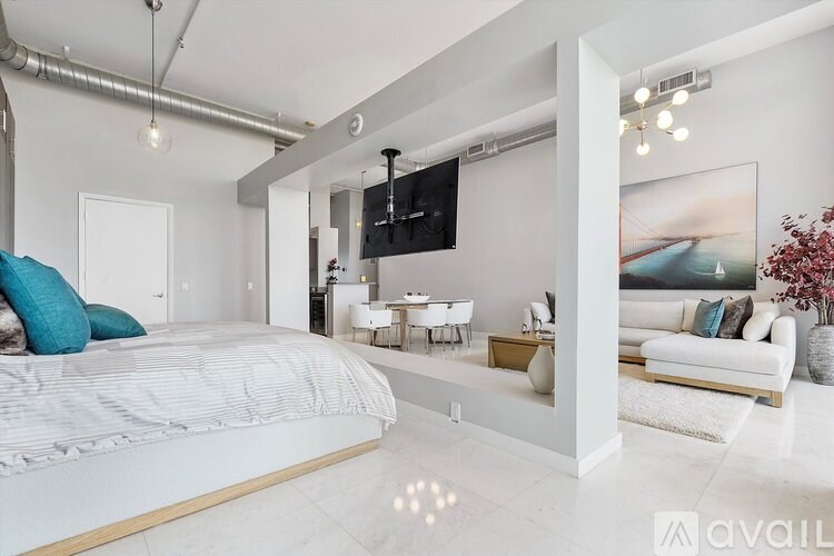 A modern bedroom with a large bed and a television mounted on the wall.