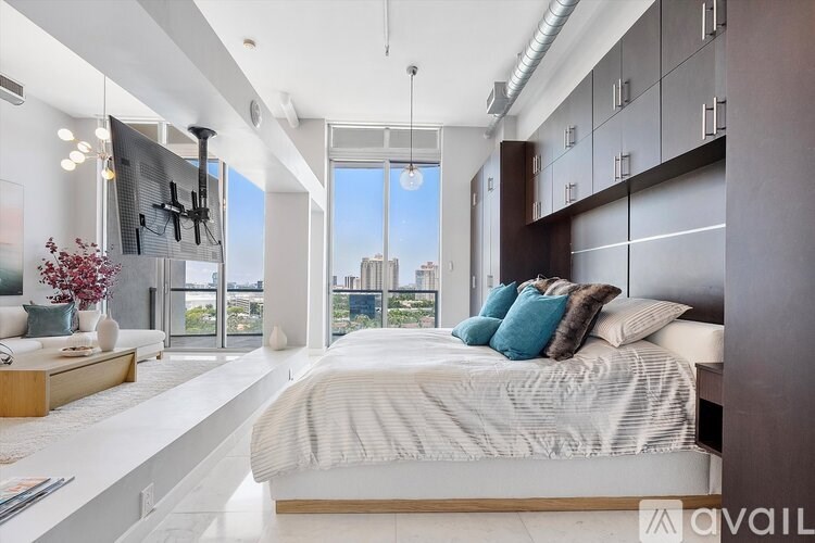 A bedroom with a large bed and a view of the city.