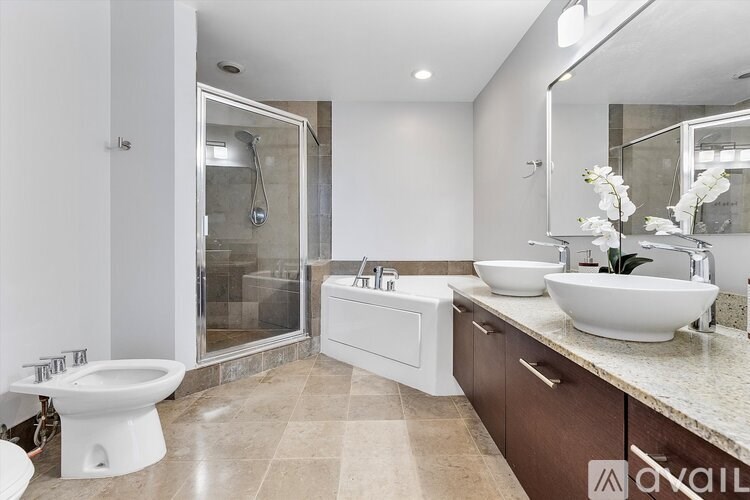 A modern bathroom with a walk-in shower and double sinks.
